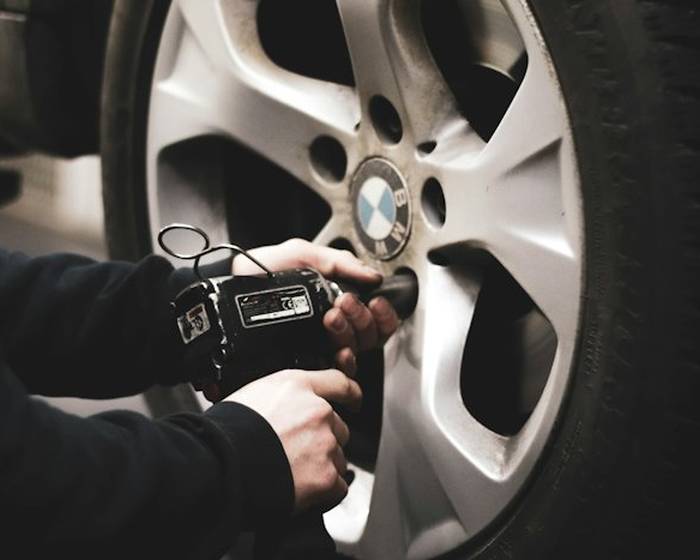 Technician torquing a wheel with an impact wrench